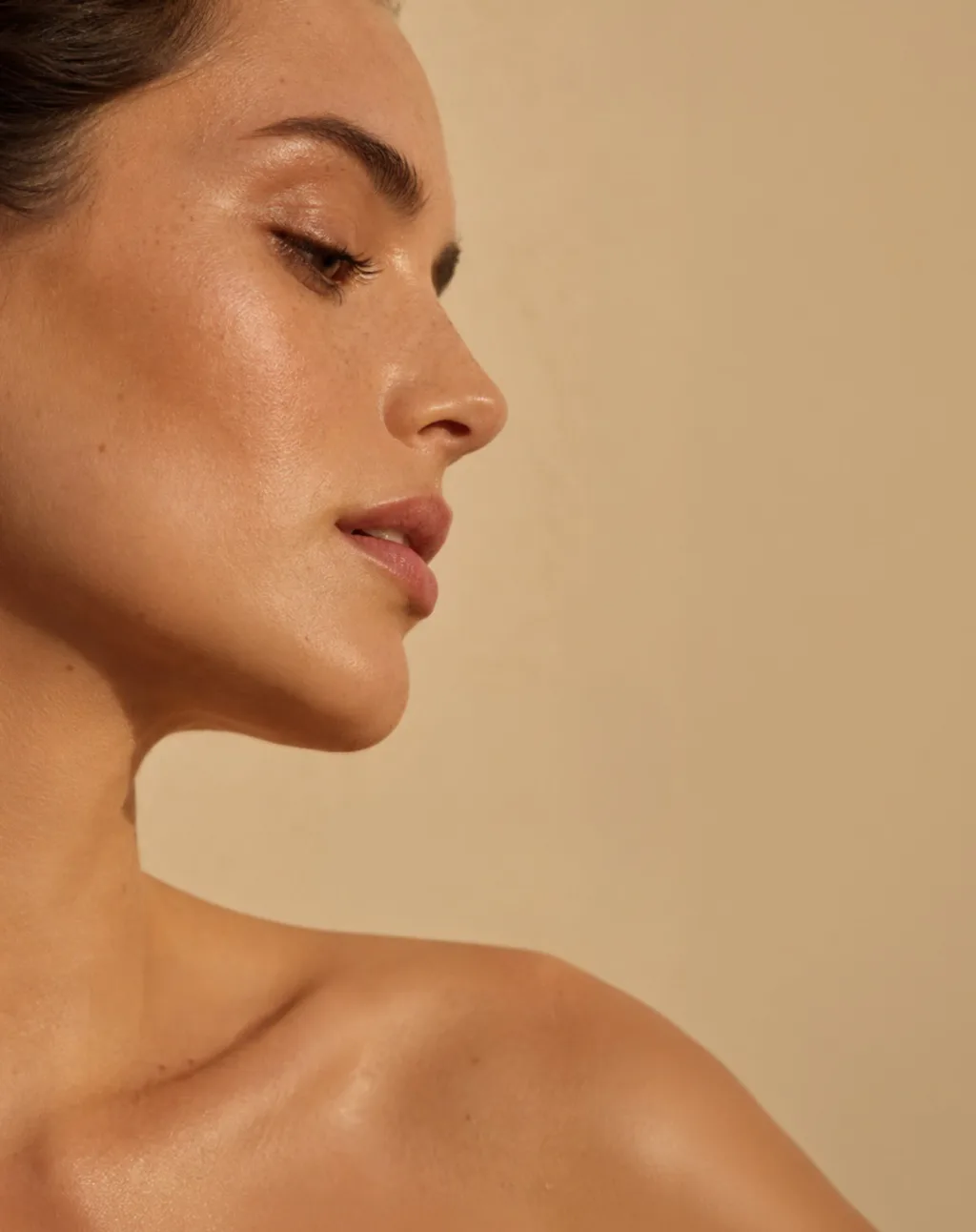 Perfil de mulher em luz difusa, sobre fundo areia